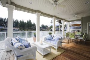Beautiful outdoor sitting area on large balcony, overlooking a lake.